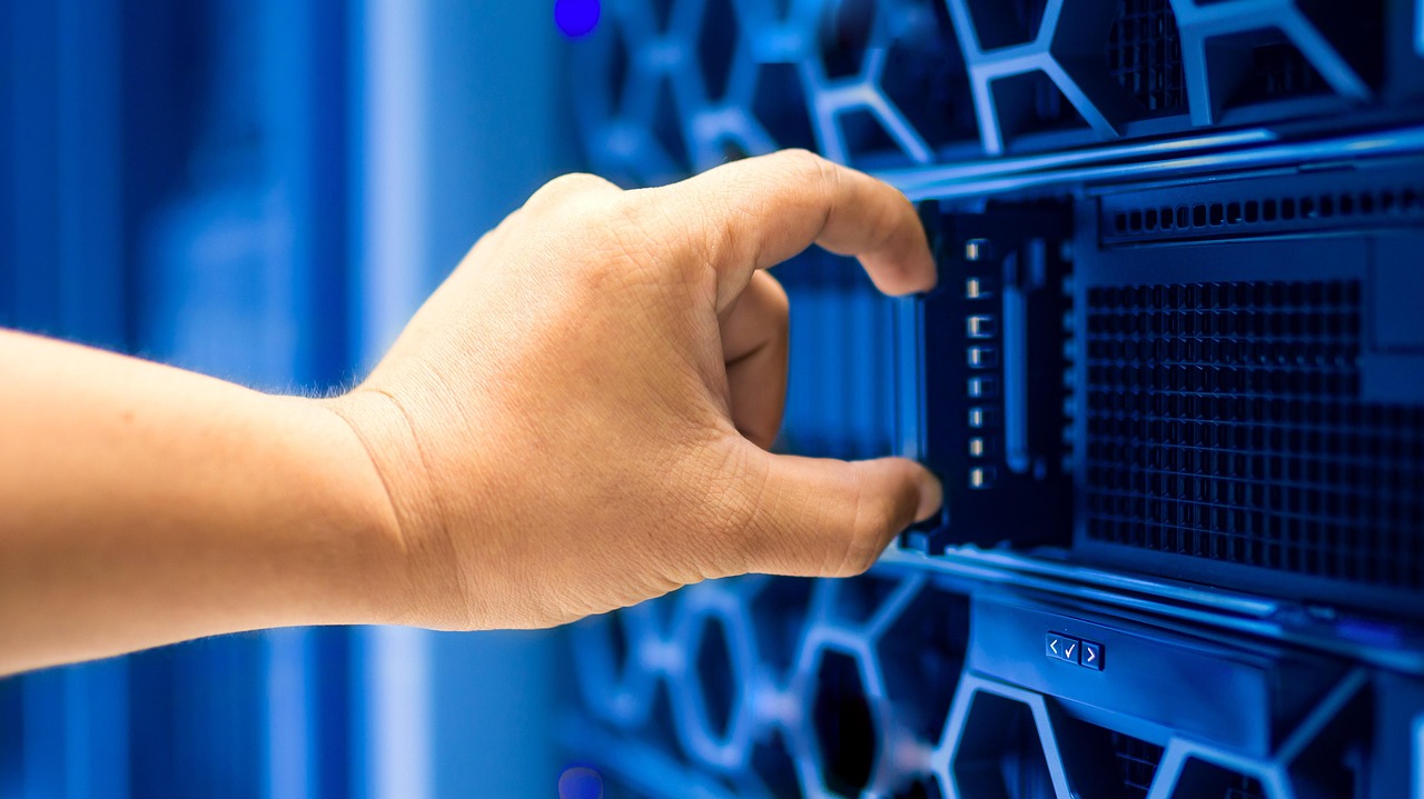 Eine Hand steckt ein Modul in ein blau beleuchtetes Server-Rack in einem Rechenzentrum - Node.js ist die Laufzeit, die diese Art von serverseitigem JavaScript antreibt.
